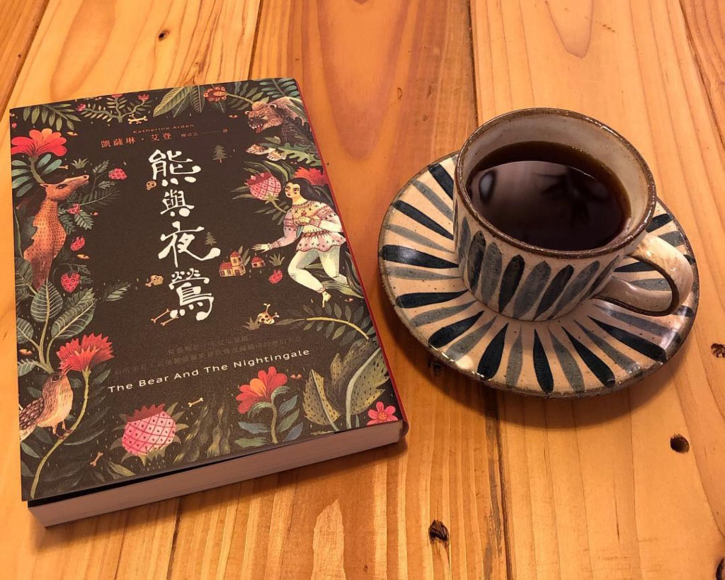 Photo of The Bear and the Nightingale book cover next to a cup of coffee